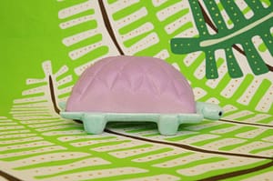 Tortu, mantequillera de cerámica con forma de tortuga, realizada por Tánata. Este modelo tiene la concha morado Un Rábano y el cuerpo verde Casitas.